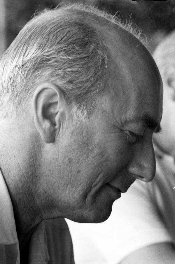 A black and white portrait shows an older man with short gray hair, contributing to television discussion.